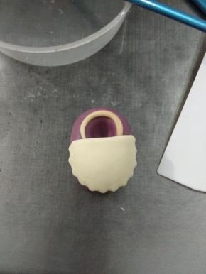 用波浪圆圈压出一个波浪圆形，切掉1/3，贴在圆条下方，盖住圆条尾端