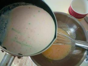 煮好的液体快速倒入蛋黄中。边倒边搅拌，避免蛋黄被烫熟。