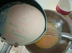 煮好的液体快速倒入蛋黄中。边倒边搅拌，避免蛋黄被烫熟。