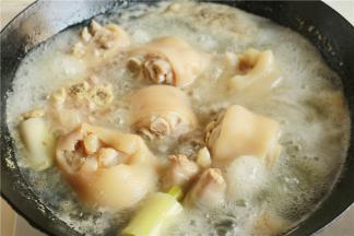 猪蹄冷水下锅，加入葱段姜片和花椒，烧开后再煮5分钟左右，能看到血沫都煮出来了。