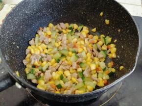 最后倒入黄瓜丁、胡萝卜丁和玉米粒炒2分钟左右，炒至水分收干即可
