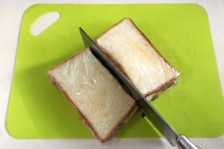 保鲜膜裹紧，用刀把三明治一切为二即可。