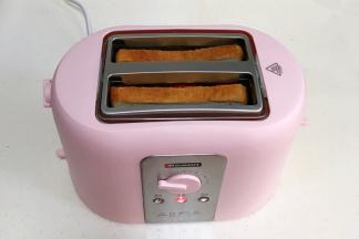 取两片吐司放入多士炉中，开一档烘烤。