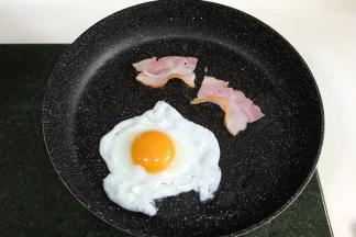 用不粘锅煎个蛋和两片培根。