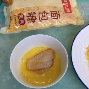 鸡蛋打散，将腌好的鸡翅裹上鸡蛋液。