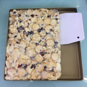 倒入不粘烤盘中，趁热用刮板按压整理成长方形，再撒上奶粉（分量外）。