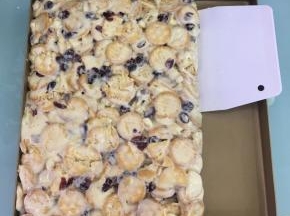 倒入不粘烤盘中，趁热用刮板按压整理成长方形，再撒上奶粉（分量外）。