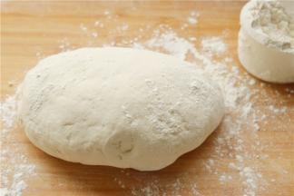 在案板上撒一些干粉，发酵好的面图使劲揉一会，使面团细腻，做出来的包子表面会更光滑。