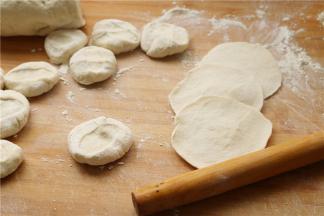 把面剂子按扁，再擀成边缘略薄，中间厚的面片，包子皮不要擀太薄，太薄了容易露馅，也不会太好看。