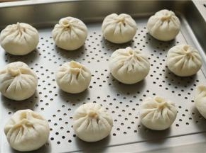 全部做好的包子，放在蒸烤箱的烤盘里，中间留有间隙，再松弛醒发20分钟左右。我放在蒸烤箱里面发酵，我用的是美的蒸烤箱，发酵时全是细密的蒸汽，特别赞。