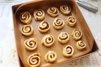 切好的胚子卷卷，平排放在学厨11寸深烤盘里，开始放在温暖湿润的地方发酵。