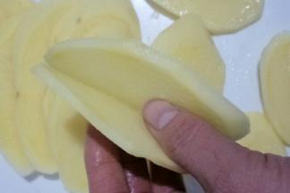 首先把土豆切成两片相连的薄片，如图