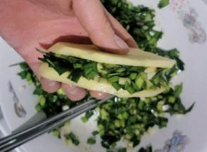 把韭菜馅放入土豆片中，如图