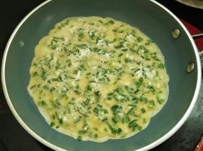 把面糊倒入不粘平底锅中，晃动锅子，让它均匀的铺上一层