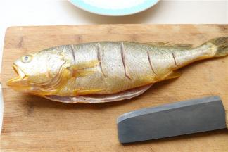 黄花鱼一条，去除鱼鳞，内脏和鱼鳃等，清洗干净后擦干水分，表面打上花刀。