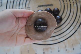 取一个可可面团压扁，包入豆沙馅。