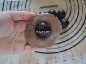 取一个可可面团压扁，包入豆沙馅。