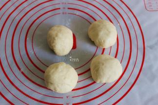 把发酵好的面团，挤出面团内的空气，分成4个小面团，滚圆，进行20分钟的发酵