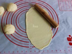 发酵好的面团压平，用擀面杖擀薄成椭圆形。