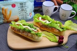 在切口处放入生菜，沙拉酱，然后放入烤熟热的牛肉肠热狗，热狗表面挤一条沙拉酱，面包就做好了。其中热狗，放入烤箱180度烤10分钟即可。