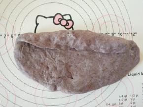 取一个面团，擀成椭圆形，翻面，横放，从上到下卷起，收紧封口处