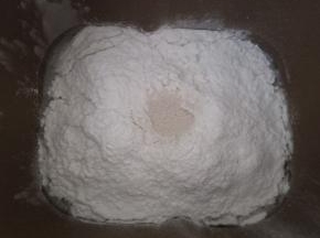 面包机先放入豆浆，对角放盐和糖，再放入高筋面粉，中间挖个洞放入酵母埋起来。