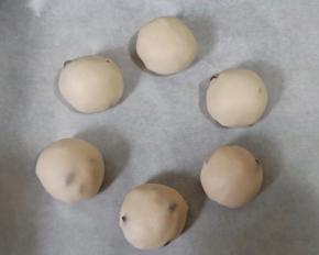 将面团6个一组放入垫好油纸的烤盘，摆成花环的造型，中间保持一定距离。