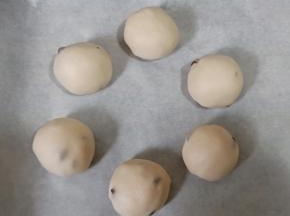 将面团6个一组放入垫好油纸的烤盘，摆成花环的造型，中间保持一定距离。