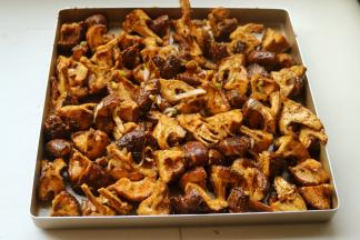 拌好的香菇放入烤盘，摊开一点，均匀地平铺在盘子里。