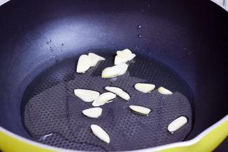 锅中倒入适量的食用油烧热，放入蒜片爆香