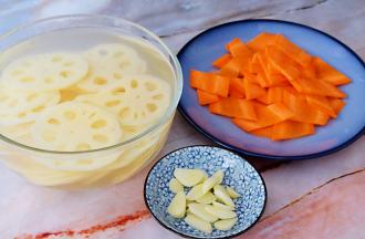 莲藕洗净切成薄片，放入白醋水中浸泡备用，放入白醋水是为了防止氧化变黑，胡萝卜去皮洗净切薄片，蒜切片