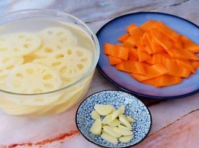 莲藕洗净切成薄片，放入白醋水中浸泡备用，放入白醋水是为了防止氧化变黑，胡萝卜去皮洗净切薄片，蒜切片