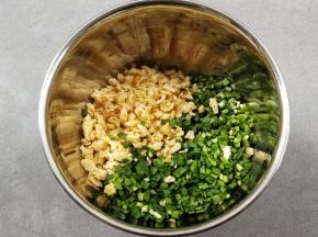 把洗净晾干水份的韭菜切成沫，和鸡蛋一起放入碗中。