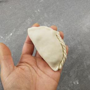 对叠成半圆形，然后再捏出花边，不捏也没关系，只要把口收紧就行。