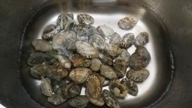 花蛤浸泡在水中，加入一勺盐泡一小时，让花蛤尽情吐出沙子来。