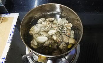 锅里放入没过花蛤的水，放入姜片和料酒大火煮，煮至花蛤全部张开了，关火。