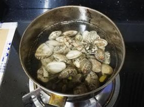 锅里放入没过花蛤的水，放入姜片和料酒大火煮，煮至花蛤全部张开了，关火。
