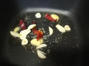 锅里热油，放入干辣椒、姜蒜片爆香