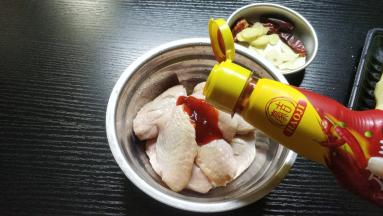 鸡翅用厨纸吸干水份，加入1勺豪吉川香汁、老干妈
