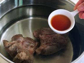 焯烫后，温水冲洗掉杂质。换一锅热水，将处理干净的牛腿肉放入炖锅中，加入花雕酒