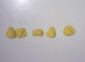 黄色面团分出4个豌豆粒大小的面团，分别搓长条制作出生，日，快，乐四个字