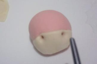 粘少量清水贴在马头窄的那一面，用筷子扎两个鼻孔，如图