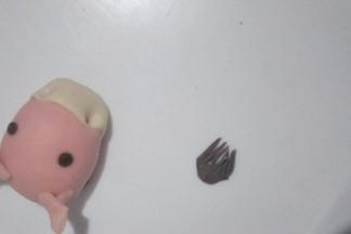 把马眼睛搓圆粘少量清水贴在马头部相应位置，奥利奥鬃毛面团搓水滴状，用剪刀剪几刀，如图