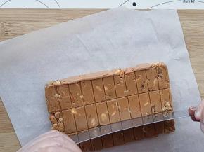 在还有余温的时候用阳晨牛轧糖切刀按照压好的格来切块。不要等凉了再切。切好可以放进包装袋，或者放在小盒里。冷藏保存。