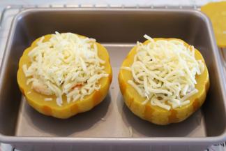 听到烤箱提示音后取出南瓜，拿掉盖上和牙签，表面铺上马苏里拉芝士碎。