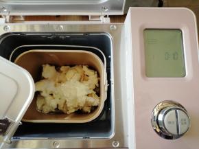 将中种面团撕成小块放入到面包桶里，倒入16克蛋清、30克糖、3克盐、8克奶粉和1克酵母