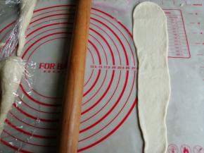 将面团擀成倒三角形，翻面，光滑面朝下