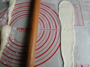 将面团擀成倒三角形，翻面，光滑面朝下