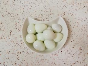 另起锅将鹌鹑蛋煮熟剥皮。