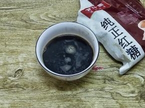 取25克的纯正红糖放入碗中，加入热水化开成糖水各用